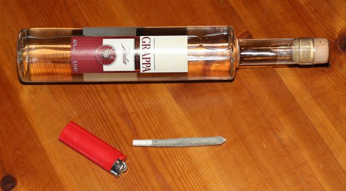 Mischkonsum – Joint mit Feuerzeug vor einer Spirituosenflasche